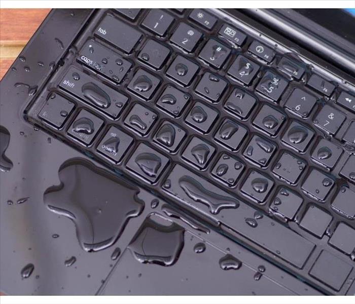 Above view of laptop with water drop damage liquid wet and spill on keyboard, accident concept.